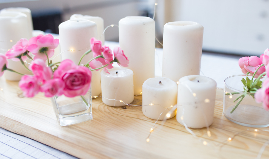 tipos de iluminacion de comedor - velas blancas, luces amarillas y flores color rosa