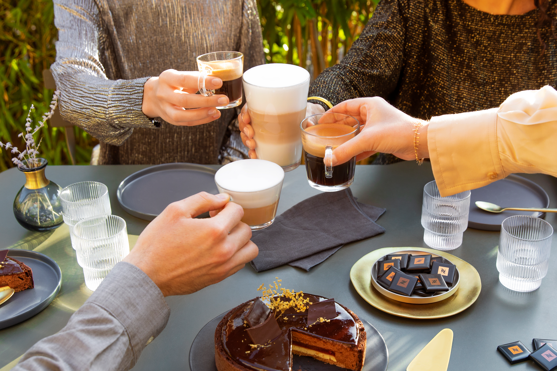 mujer sosteniendo una taza de caf� mientras sus amigos comen